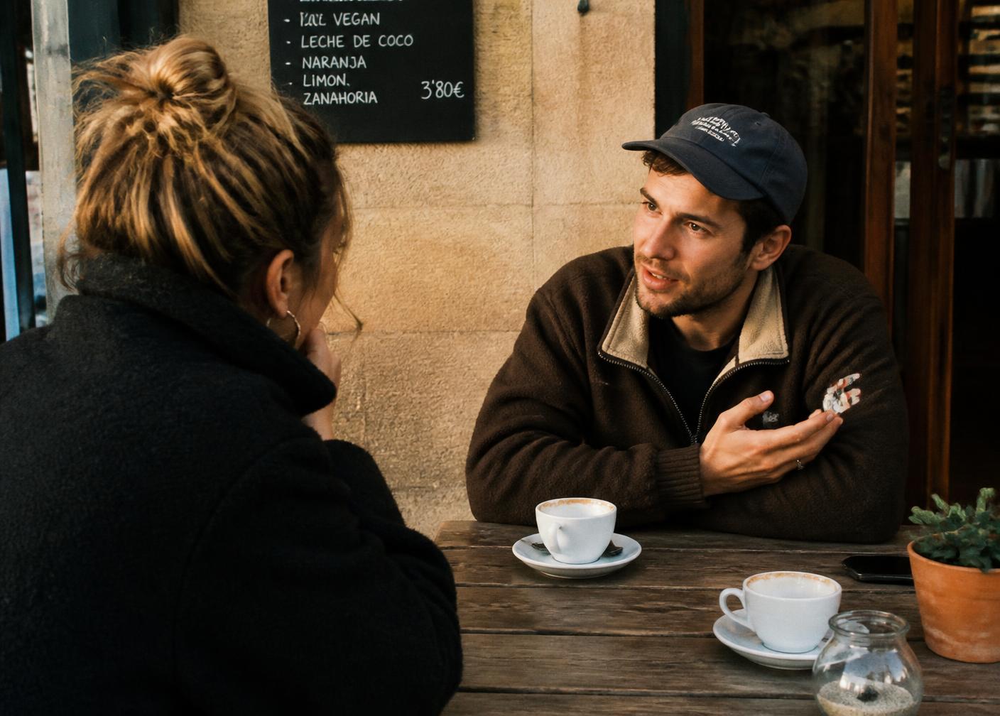 Two people in conversation over coffee at a small Mallorca café